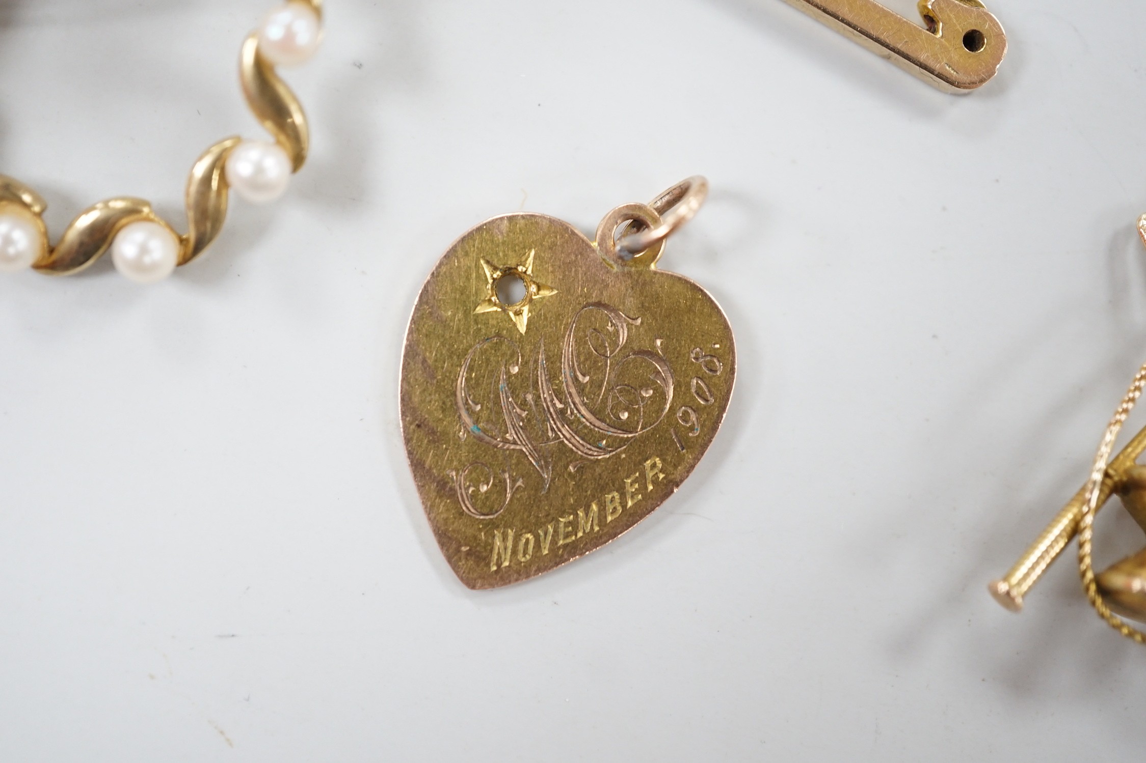 An Edwardian 9ct gold heart pendant (stone missing), 18mm, a yellow metal diablo charm and two brooches including 9ct bar brooch, gross weight 8.1 grams.